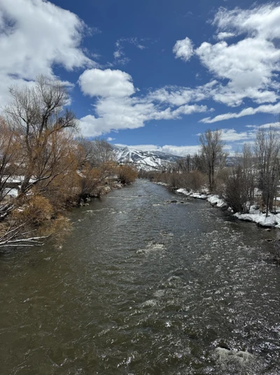 A snowy river with Colorado mountains in the background